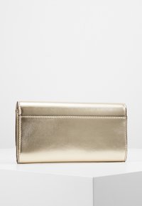 Portefeuille métallique doré, forme rectangulaire, texture lisse, avec une fermeture à rabat et des bords cousus. Design minimaliste sans ornements.