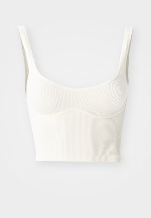 Kreemjas tooni ribakujuline lühikeste varrukatega topp, millel on laiad õlarihmad ja pehme, sile tekstuur. Omab kontuuritud rinnaõmblust ja sirget äärt.