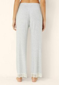 Grijze katoenen loungebroek met een losse pasvorm, met een kantafwerking aan de zoom. Elastische tailleband voor comfort en gemakkelijke bediening.