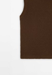 Bruine gebreide mouwloze top met een textuur patroon. De stof is lichtgewicht, met ribbelrand langs de armsgaten en de zoom.