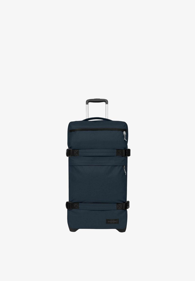Valise à roulettes bleu foncé avec poignée télescopique, deux compartiments zippés et sangles de compression noires réglables sur fond blanc.