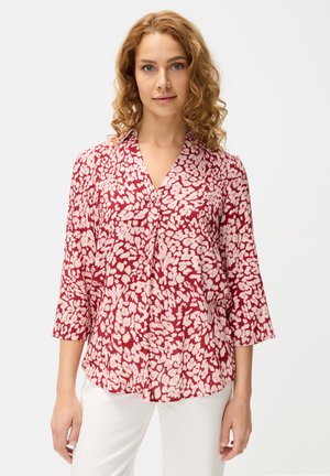Rote und rosa florale Bluse mit Dreiviertelärmeln, kragenlosem Ausschnitt und einem leichten Stoff, der ein verstreutes Druckmuster aufweist.