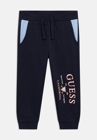 Μπλε σκούρο παντελόνι φόρμας με ανοιχτό μπλε τσέπες, ελαστική μέση, μανσέτες στα πόδια και εκτυπωμένες λεπτομέρειες λογότυπου στο αριστερό πόδι.