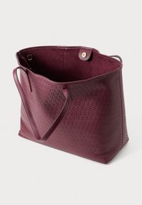 Maroon tote bag with a textured woven pattern, leather material, open top, and a snap closure. Interior features a soft lining.