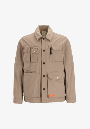 Veste utilitaire beige avec plusieurs poches, fermeture éclair et une poche zippée. Texture lisse, design structuré, avec une étiquette orange contrastante.