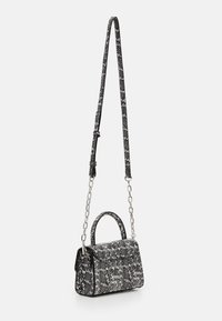 Borsa a mano con un motivo bianco e nero, dalla forma strutturata, con catena e manico superiore, caratterizzata da hardware lucido e materiale testurizzato.