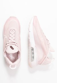 Ljusrosa träningsskor med ovandel i mesh och syntetmaterial, snörning, vadderad krage och synlig luftkudding i sulan.