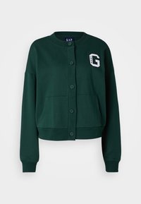 Grüne Sweatjacke mit Rundhalsausschnitt, Knopfverschluss, zwei Fronttaschen und einem weißen 'G'-Patch. Aus weichem Material mit verkürztem Design gefertigt.