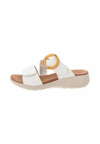 Sandal bianca con una soletta marrone, caratterizzata da due fascette larghe e un accento arancione circolare sul lato. Suola testurizzata per una migliore aderenza.