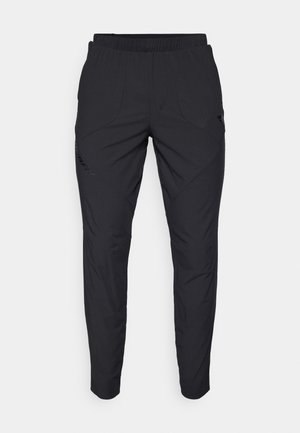 Czarne spodenki sportowe z elastycznym pasem, o gładkiej fakturze, zwężających się nogawkach, ukośnych kieszeniach oraz subtelnym logo.