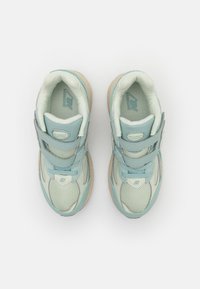 Šviesiai mėlyni sportiniai batai su tinkline ir sintetine viršutine dalimi, paminkštintu apykakle, dviem Velcro juostomis ir smėlio spalvos guminiu padu.