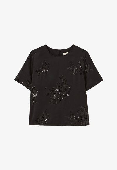 Blusa nera a maniche corte con sottili adornamenti floreali in paillettes sparsi sul davanti e sulle maniche, scollatura rotonda e chiusura con cerniera sul retro.