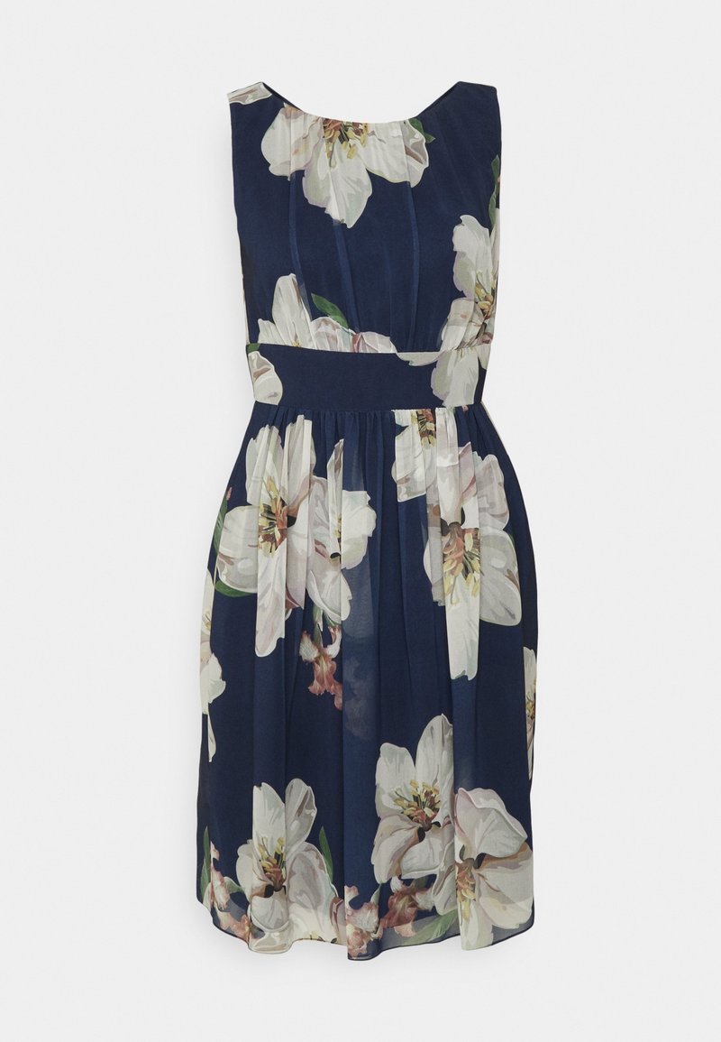 Robe bleu marine sans manches avec grand imprimé floral blanc, taille cintrée et jupe froncée tombant au-dessus du genou.