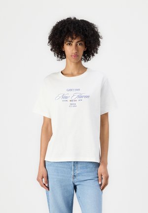 T-shirt bianco in cotone con vestibilità rilassata, maniche corte, scollatura rotonda e scritta grafica blu che recita "GANT 1949 New Haven" nella parte anteriore.