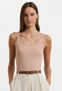 Ροζ ριγωτό αμάνικο μπλουζάκι με στρογγυλή λαιμόκοψη και φαρδιές τιράντες, συνδυασμένο με κρεμ παντελόνια ψηλής μέσης και καφέ ζώνη.