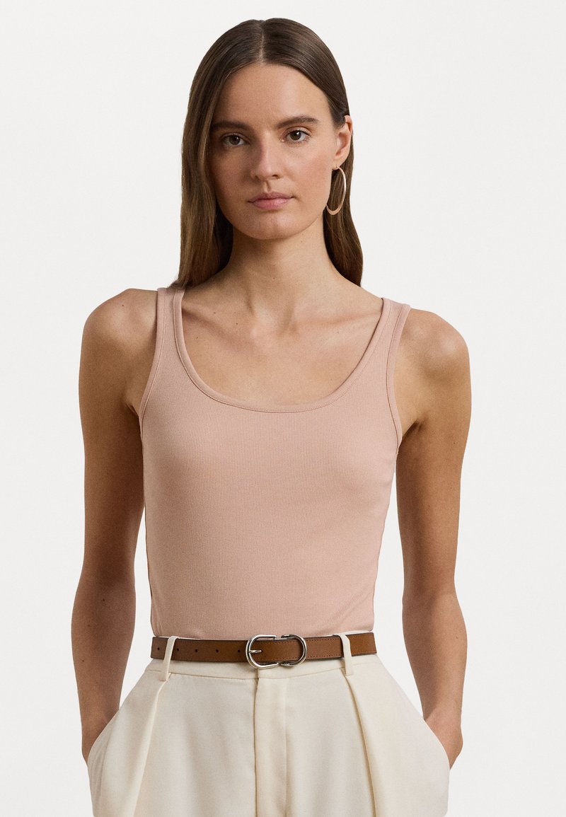 Ροζ ριγωτό αμάνικο μπλουζάκι με στρογγυλή λαιμόκοψη και φαρδιές τιράντες, συνδυασμένο με κρεμ παντελόνια ψηλής μέσης και καφέ ζώνη.