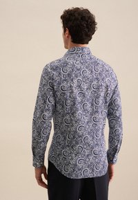 Koszula z długim rękawem w granatowym kolorze z białym wzorem paisley, z kołnierzykiem na guziki, zaokrąglonym dołem i teksturowanym materiałem.
