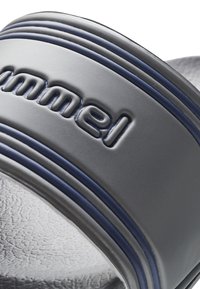 Grå gummisandal med skydesål, der har en fremtrædende mørkeblå stribe som accent og præget brandlogo på remmen. Tekstureret overflade på fodsengen.