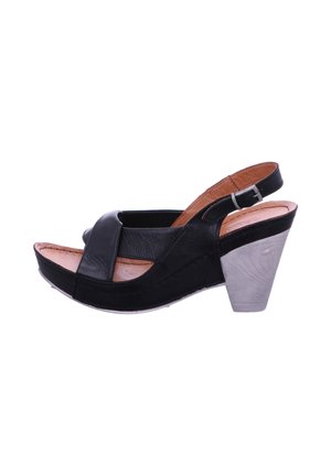 Schwarze Slingback-Sandalen aus Leder mit einem überkreuzten Riemendesign, einem beigen Innenfutter und einem strukturierten, grauen Blockabsatz.