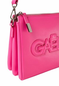 Borsa a tracolla in finta pelle rosa con logo testurizzato, chiusura con zip e tracolla removibile. Presenta un design elegante e piegato con accessori in argento.