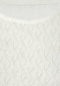 Weißer Strickstoff mit einem Rautenmuster und offenem Detail, das ein strukturiertes und leicht durchscheinendes Erscheinungsbild betont.
