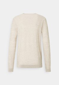 Hellbeiger Pullover mit langen Ärmeln, aus weichem Stoff. Mit einem Rundhalsausschnitt und gerippten Bündchen am Saum und an den Ärmeln.