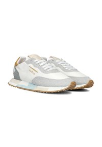 Baskets de course blanches et argentées avec un éclat métallique, tige texturée, lacets plats, et une semelle à motifs bleu clair et beige. Accents dorés sur le talon.