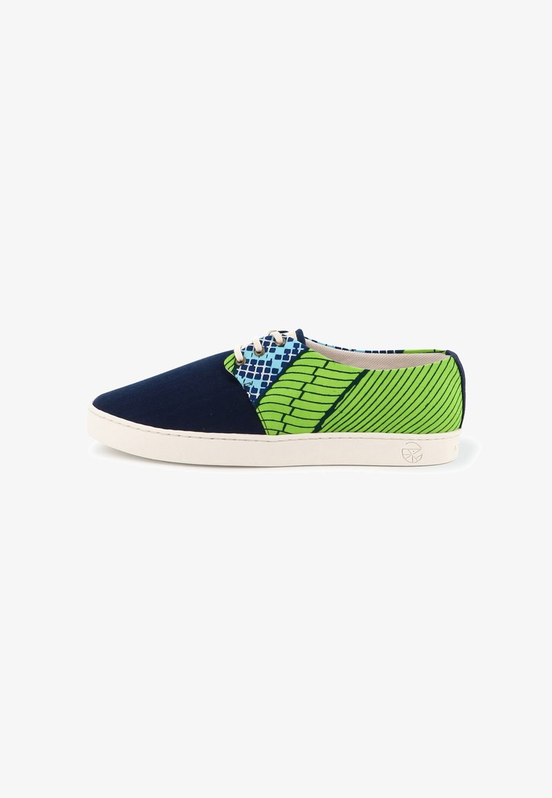 Baskets basses avec partie avant bleu marine, zone des lacets à carreaux bleus et blancs, et talon vert à motifs avec semelle blanche.