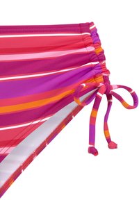 Bikini apatiniai multicolor juostelėmis: rožinė, raudona, oranžinė ir balta. Yra šoninis raištelis su susiraukšlėjusia tekstūra aplink liemenį.