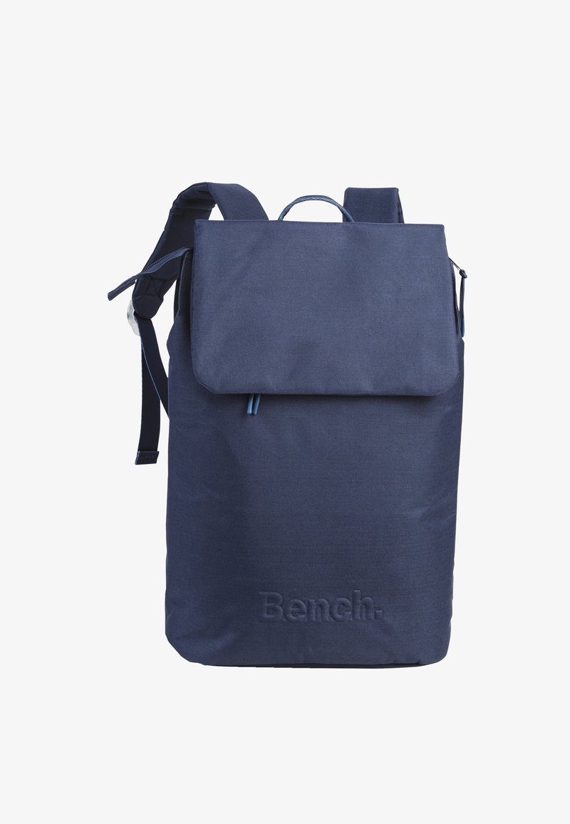 Navy blue fabric backpack with a flap closure, adjustable shoulder straps, top handle, and embossed "Bench." logo at the base.