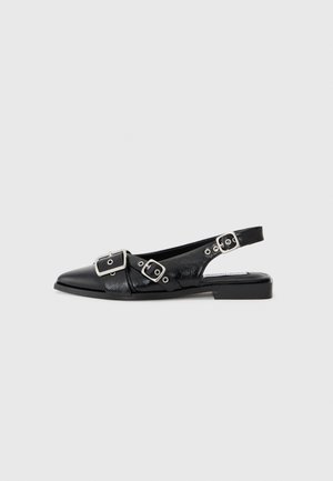 Schwarzer Lederslingback-Schuh mit flachem Absatz, spitzer Spitze und drei silbernen Schnallenriemen auf einfarbigem Hintergrund.