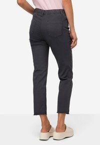 Donkergrijze stretchjeans met een elastische tailleband, vijf-pocket ontwerp en een cropped, taps toelopende pijp met onafgewerkte zoom.
