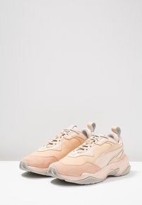 Baskets rose clair en daim et matériaux synthétiques, dotées d'une semelle épaisse, d'une fermeture à lacets et d'une languette à l'arrière.