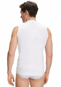 Sleeveless white jersey shirt with a high neck, smooth texture, and fitted design. Shows back view and shoulder details.