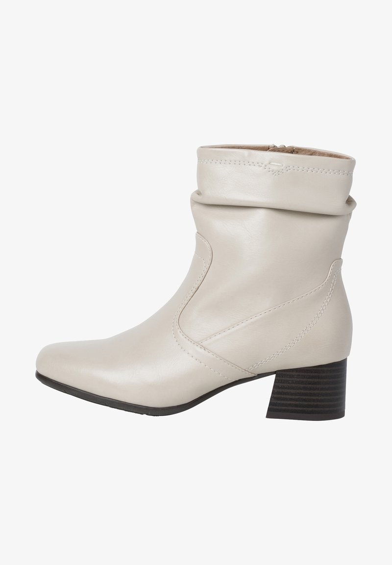 Bottine en cuir beige avec un revers souple, un bout pointu et un talon empilé. Présente des coutures discrètes et une texture lisse.