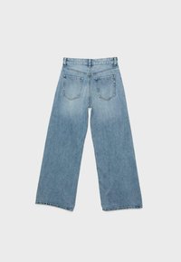 Jean en denim bleu clair à jambes larges, vu de dos, avec deux poches plaquées et des passants pour ceinture, sur un fond blanc uni.
