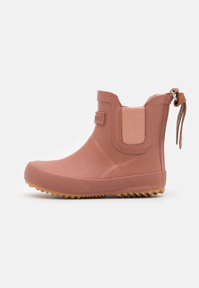 Bottine de pluie courte en caoutchouc rose pour la cheville avec semelle texturée, panneau latéral élastique et languette avec sangle en cuir à l'arrière.