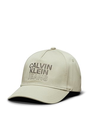 Cappellino da baseball beige realizzato in tessuto testurizzato con un visiera curva. Presenta "CALVIN KLEIN JEANS" ricamato in marrone scuro sul davanti.
