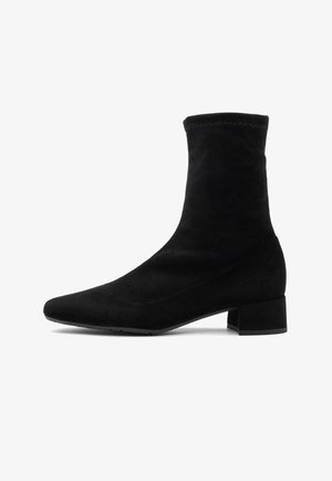 Schwarzer Wildleder-Stiefelknöchel mit spitzem Zeh, schlankem Blockabsatz und gestickten Details am oberen Rand, der ein elegantes und minimalistisches Design aufweist.