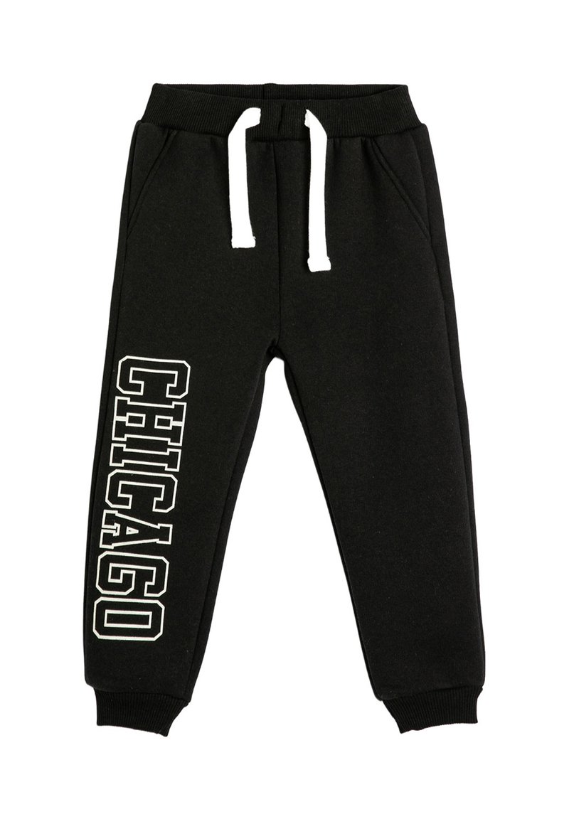 Pantalones deportivos negros con cordón blanco y texto "CHICAGO" en letras blancas en negrita verticalmente en la pierna izquierda.