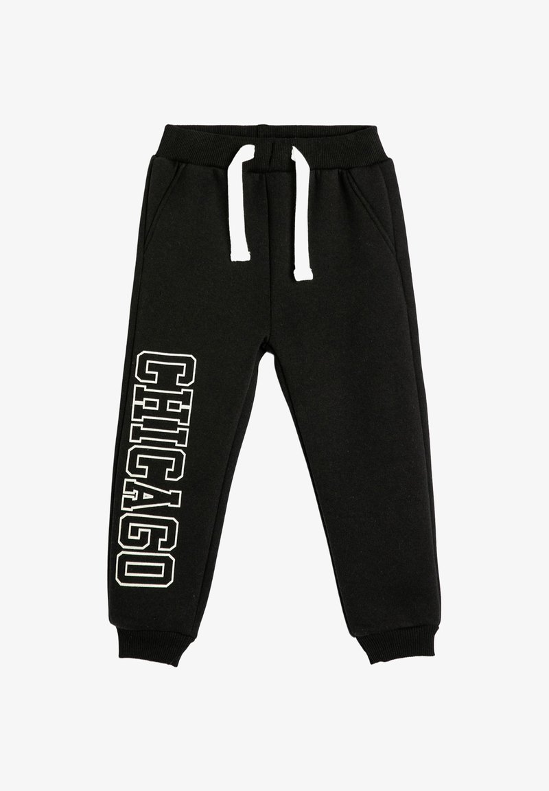 Pantalones deportivos negros con cordón blanco y texto "CHICAGO" en letras blancas en negrita verticalmente en la pierna izquierda.