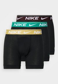 Crne bokserice s elastičnim pojasom u zelenoj, žutoj i maroon boji. Imaju Nike logotip, glatku teksturu i uski kroj.