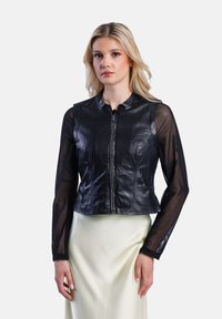 Černá kožená zkrácená bunda se zapínáním na zip, s průhlednými dlouhými rukávy a kulatým výstřihem. Hladká textura s mírným leskem.