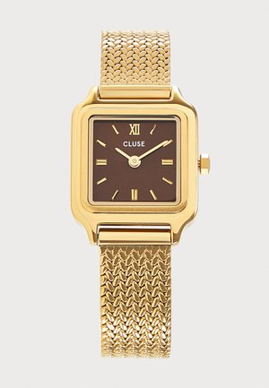 Gold square watch with brown face, gold Roman numerals, two hands showing 10:10, and a textured gold metal strap. Brand name Cluse.