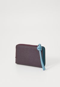 Portafoglio in pelle di colore viola scuro con una tracolla azzurra in evidenza. Texture liscia, chiusura a zip nella parte superiore e forma rettangolare con angoli arrotondati.