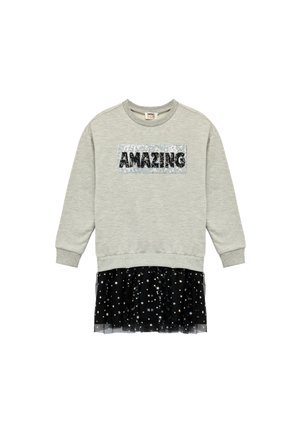 Sudadera de manga larga gris claro con "AMAZING" en lentejuelas en el frente y una falda de tul negra con patrones de estrellas plateadas en el dobladillo.
