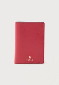 Κόκκινο δερμάτινο πορτοφόλι με υφασμάτινη επιφάνεια, διακοσμημένο με ένα χρυσό λογότυπο στο κάτω μέρος. Ορθογώνιο σχήμα με στρογγυλεμένες άκρες.