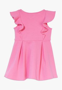 Rosa bomullsklänning med volangdetaljer på axlarna, en figursydd bodice och en utsvängd kjol. Slät textur och enfärgad genom hela plagget.