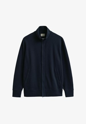 Veste bleu marine à fermeture éclair intégrale avec col montant, deux poches latérales, poignets et ourlet côtelés, présentée sur un fond blanc.