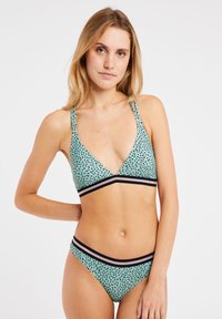 Žalias dėmėtas bikini rinkinys su trikampio formos liemenėle, kuri turi juodų ir rožinių dryžių akcentus ant juostos ir juosmens.